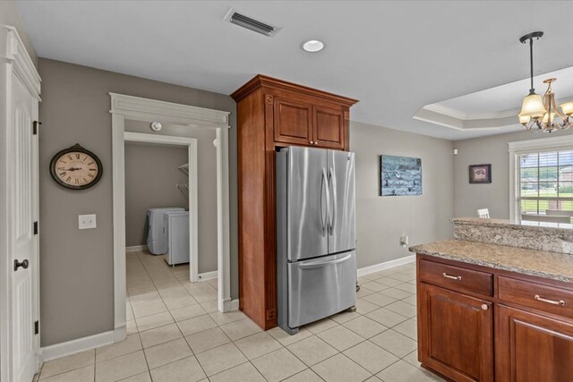 102 Tumbleweed Dr, Enterprise, AL 36330 - kitchen with freestanding refrigerator, light tile patterned floors, a chandelier, washer and clothes dryer, and crown molding