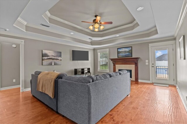 102 Tumbleweed Dr, Enterprise, AL 36330 - living room with a raised ceiling, crown molding, a ceiling fan, light wood-style flooring, and a tile fireplace