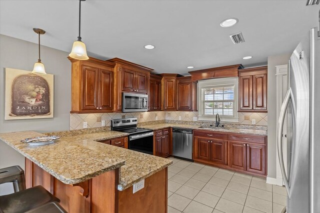 102 Tumbleweed Dr, Enterprise, AL 36330 - kitchen with stainless steel appliances, a peninsula, backsplash, light tile patterned floors, and pendant lighting