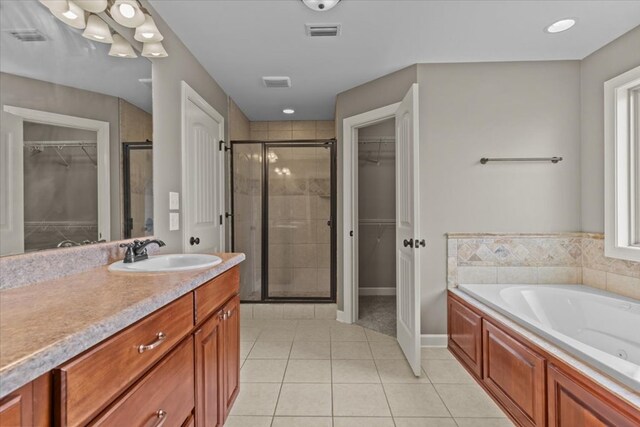 102 Tumbleweed Dr, Enterprise, AL 36330 - full bathroom featuring a shower stall, vanity, a walk in closet, tile patterned flooring, and a jetted tub