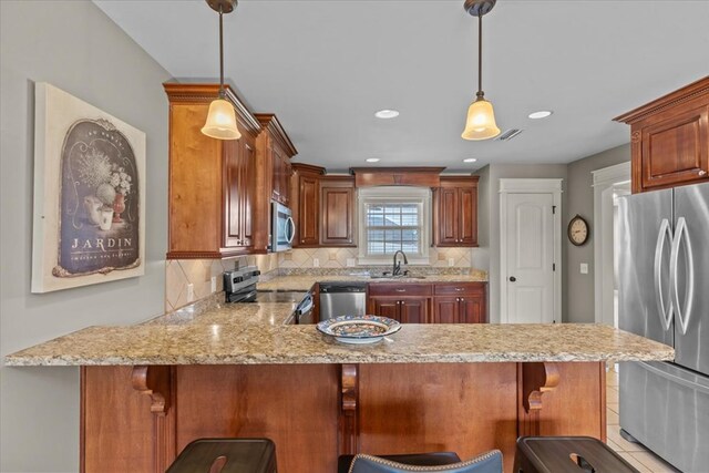 102 Tumbleweed Dr, Enterprise, AL 36330 - kitchen with appliances with stainless steel finishes, a peninsula, decorative backsplash, hanging light fixtures, and recessed lighting