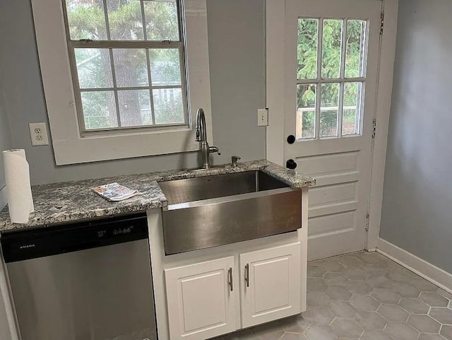 kitchen with light tile patterned flooring, plenty of natural light, a sink, and dishwasher