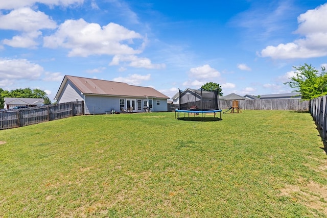 view of yard with a trampoline and a fenced backyard