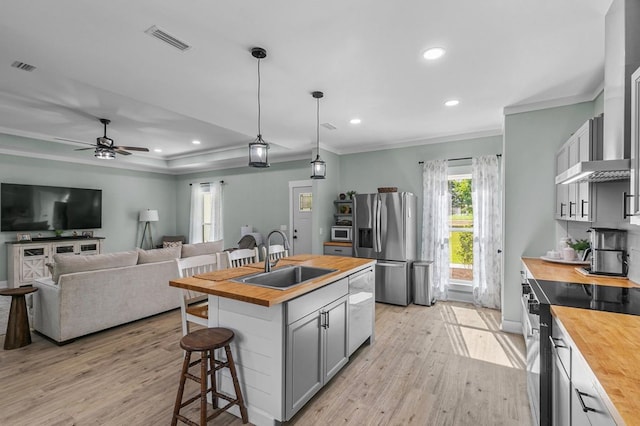 3155 Eddins Rd, Dothan, AL 36301 - kitchen with wooden counters, appliances with stainless steel finishes, light wood finished floors, a breakfast bar, and crown molding
