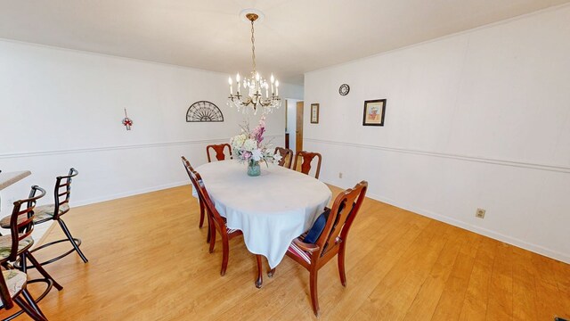 dining area featuring a chandelier, baseboards, and light wood-style floors