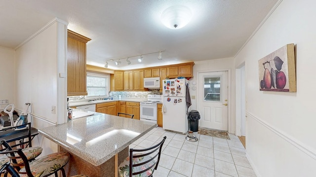 kitchen with a kitchen bar, white appliances, a peninsula, light countertops, and light tile patterned floors