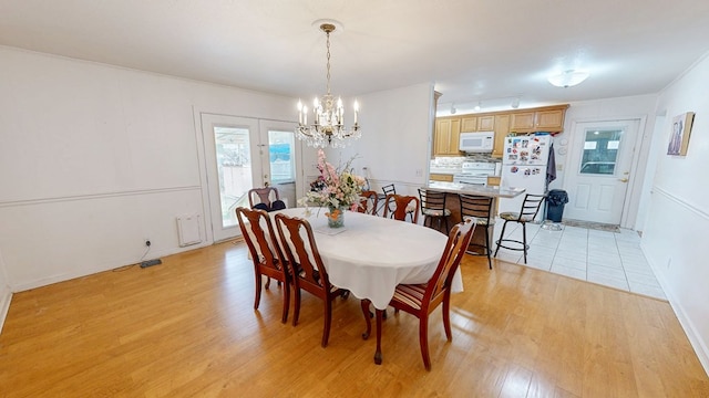 dining space featuring an inviting chandelier and light wood-style flooring