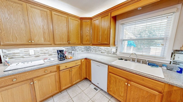 kitchen featuring dishwasher, light countertops, decorative backsplash, light tile patterned flooring, and a sink