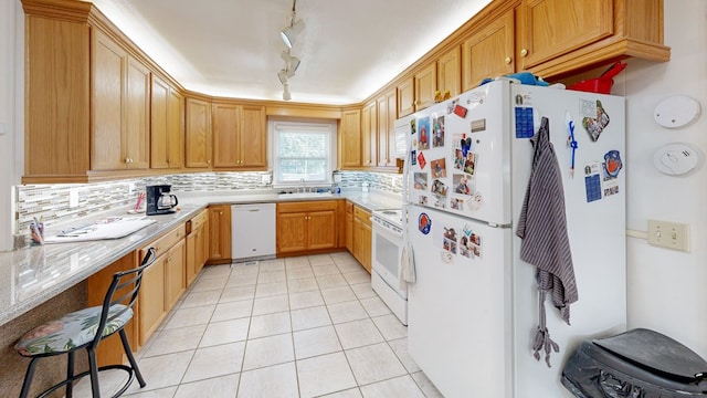 kitchen with decorative backsplash, white appliances, light tile patterned floors, and a sink