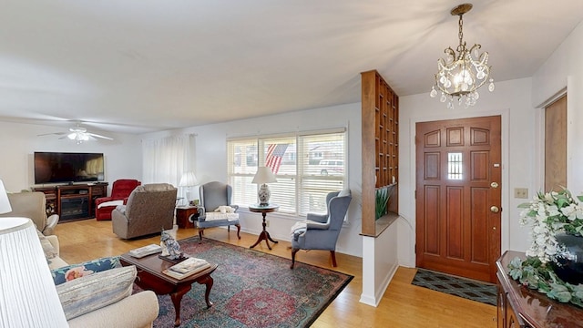 foyer entrance featuring ceiling fan with notable chandelier and light wood finished floors