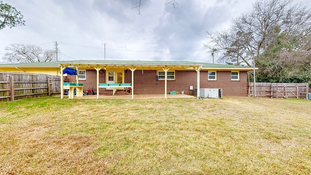 rear view of property featuring brick siding, a patio area, and a fenced backyard