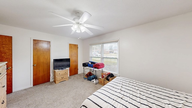 bedroom featuring light colored carpet and a ceiling fan