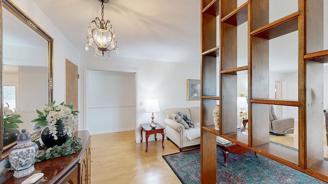 living area with light wood-style floors and a chandelier