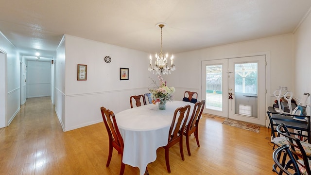 dining space with french doors, light wood-type flooring, and baseboards