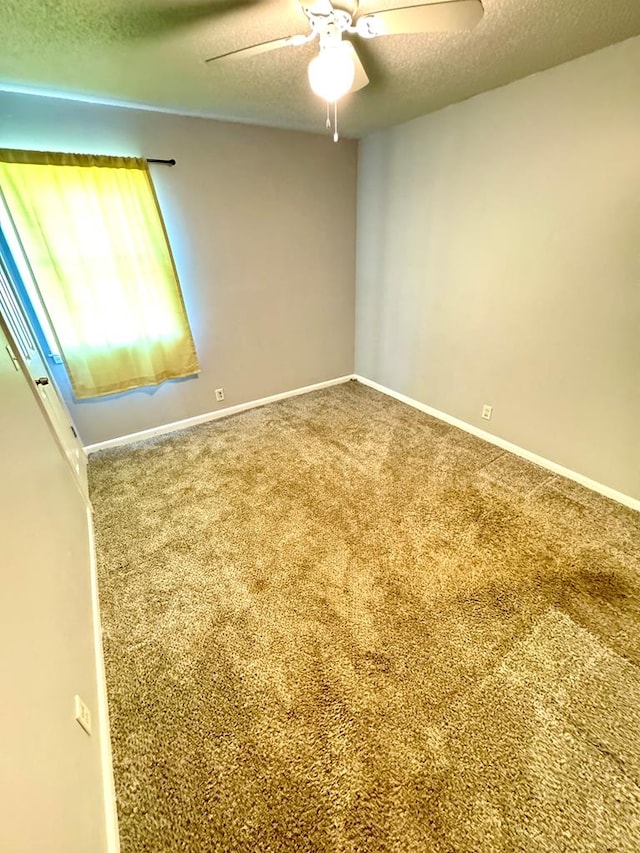 spare room featuring ceiling fan, carpet, and a textured ceiling