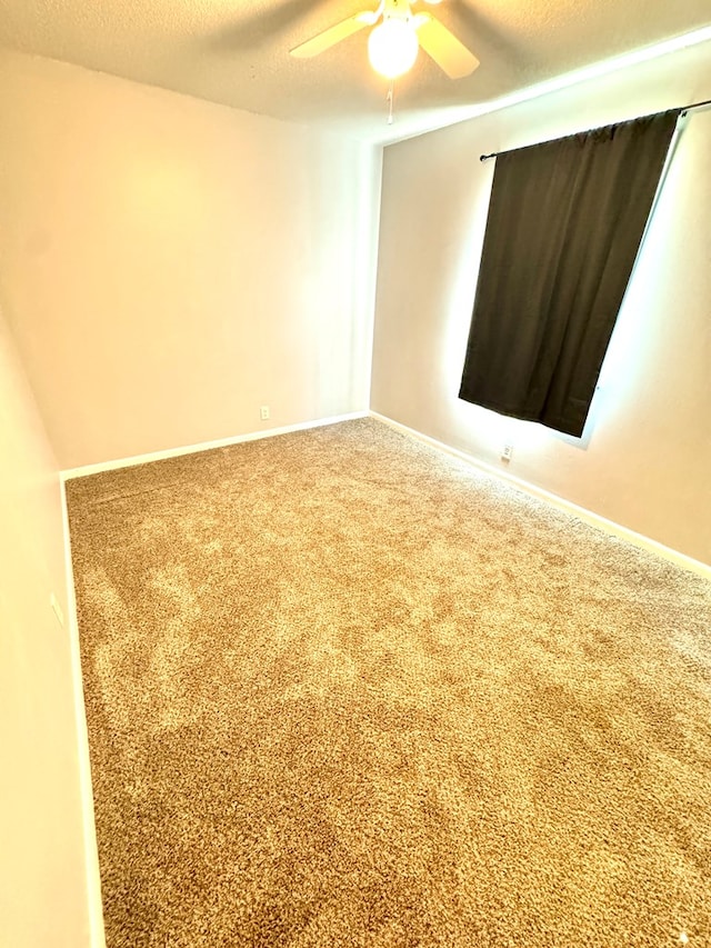 spare room featuring carpet, a textured ceiling, and ceiling fan