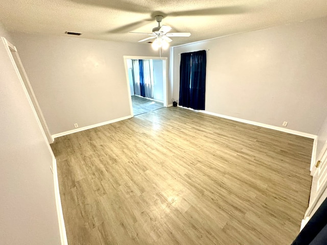 spare room featuring ceiling fan, a textured ceiling, and light hardwood / wood-style flooring