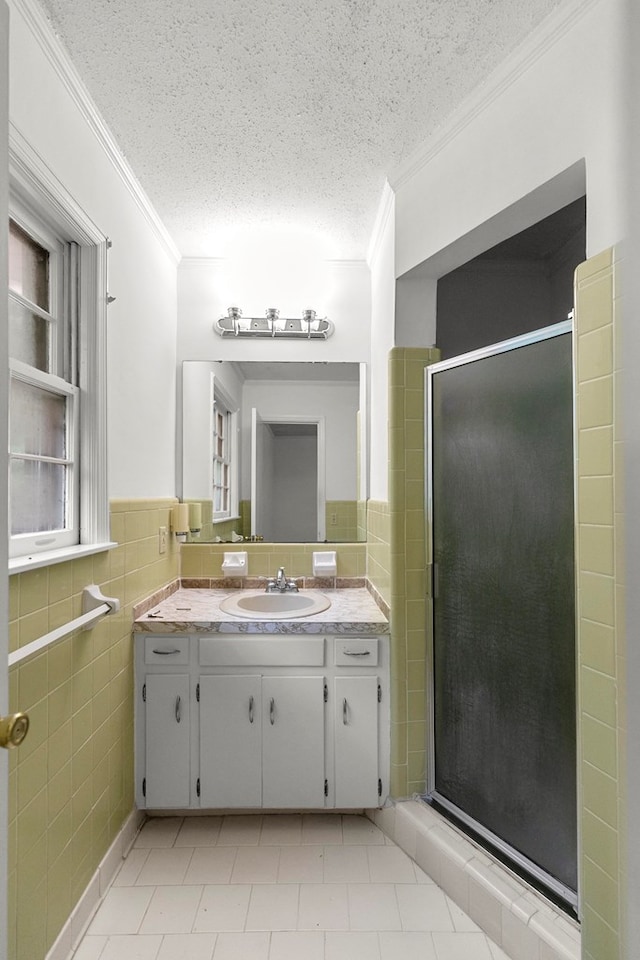 1700 Randall Rd, Dothan, AL 36303 - bathroom with tile walls, ornamental molding, a textured ceiling, vanity, and a stall shower