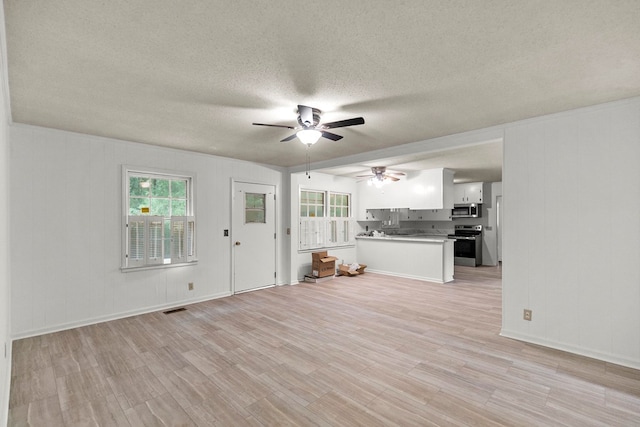 1700 Randall Rd, Dothan, AL 36303 - unfurnished living room with a ceiling fan, a textured ceiling, light wood-style flooring, and baseboards