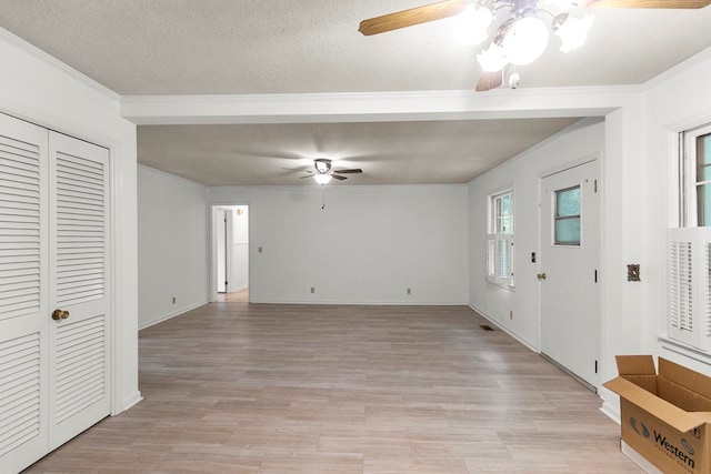 1700 Randall Rd, Dothan, AL 36303 - unfurnished living room featuring a ceiling fan, light wood-style floors, a textured ceiling, ornamental molding, and baseboards