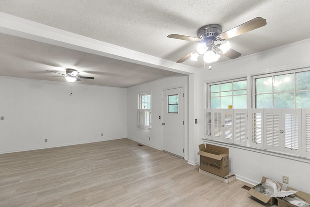1700 Randall Rd, Dothan, AL 36303 - unfurnished living room featuring a ceiling fan, a textured ceiling, light wood-style flooring, and baseboards