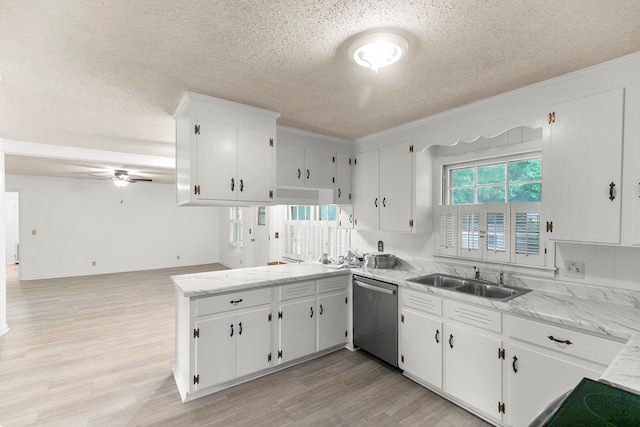 1700 Randall Rd, Dothan, AL 36303 - kitchen with stainless steel dishwasher, a textured ceiling, a sink, a peninsula, and light wood finished floors