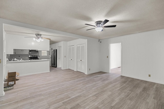 1700 Randall Rd, Dothan, AL 36303 - unfurnished living room featuring a ceiling fan, a textured ceiling, light wood finished floors, and baseboards