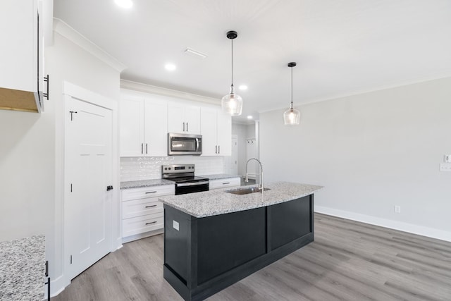 kitchen with white cabinets, an island with sink, light stone countertops, stainless steel appliances, and a sink