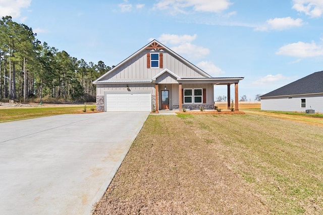 view of front facade featuring an attached garage, covered porch, driveway, a front lawn, and board and batten siding