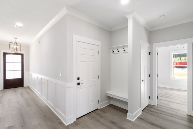 mudroom with crown molding, wainscoting, a notable chandelier, and light wood-style floors