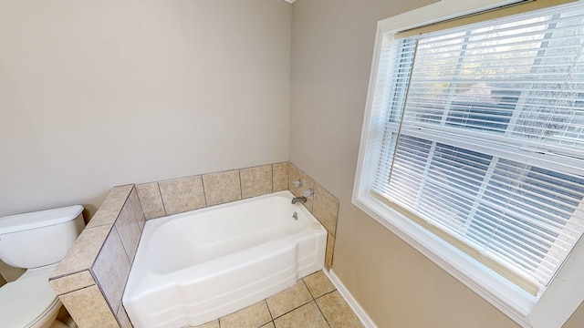 bathroom featuring toilet, tile patterned flooring, and a tub