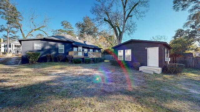 rear view of property featuring a deck and a yard