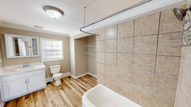 bathroom featuring toilet, vanity, hardwood / wood-style floors, crown molding, and a textured ceiling