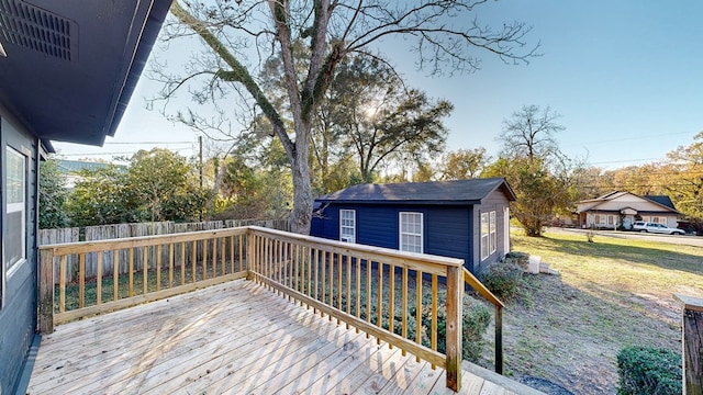 wooden deck with a yard and a storage unit