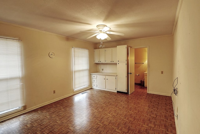 interior space with ceiling fan, ornamental molding, dark parquet floors, and a textured ceiling