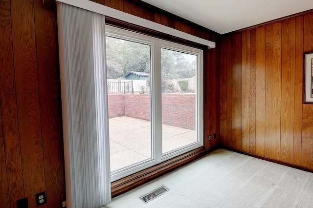 unfurnished room with light carpet and wooden walls