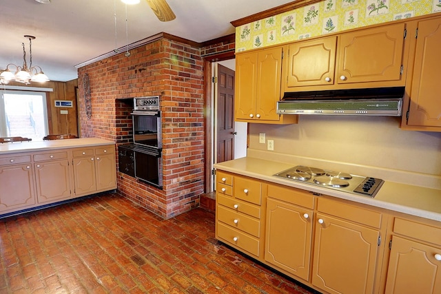 kitchen featuring ceiling fan with notable chandelier, gas cooktop, double oven, and decorative light fixtures