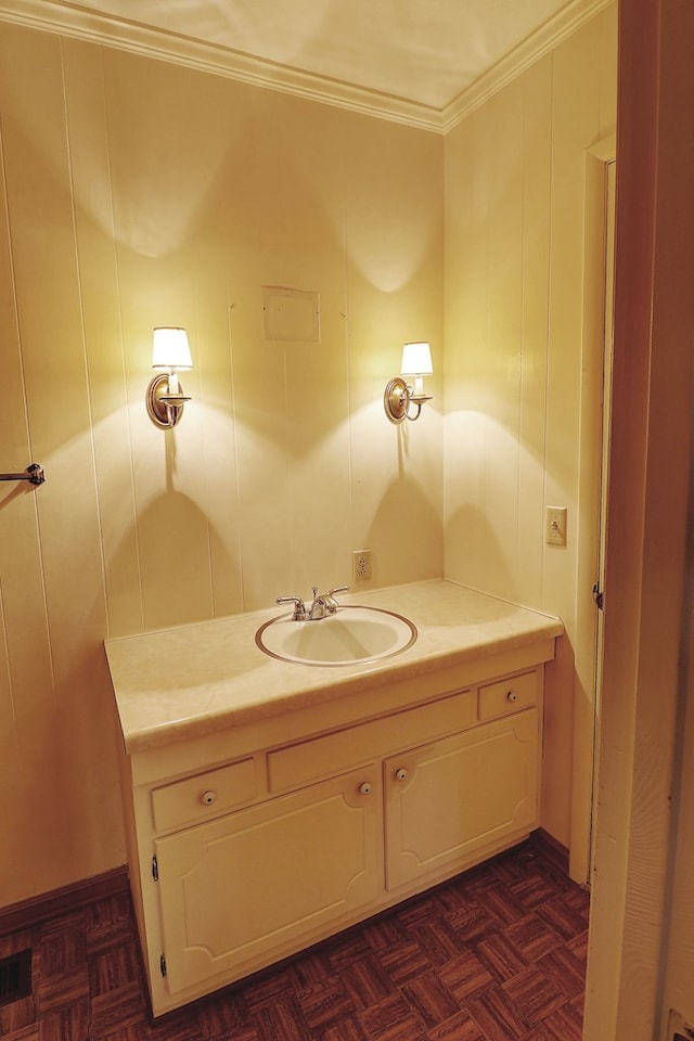 bathroom featuring parquet flooring, ornamental molding, and vanity