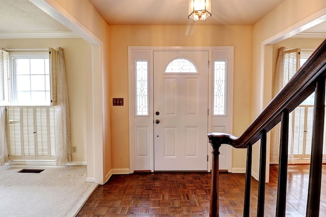 foyer entrance with dark parquet flooring and plenty of natural light