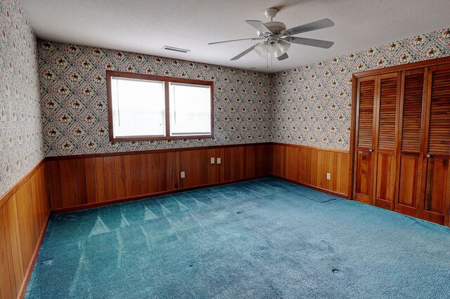 carpeted spare room with ceiling fan and a textured ceiling