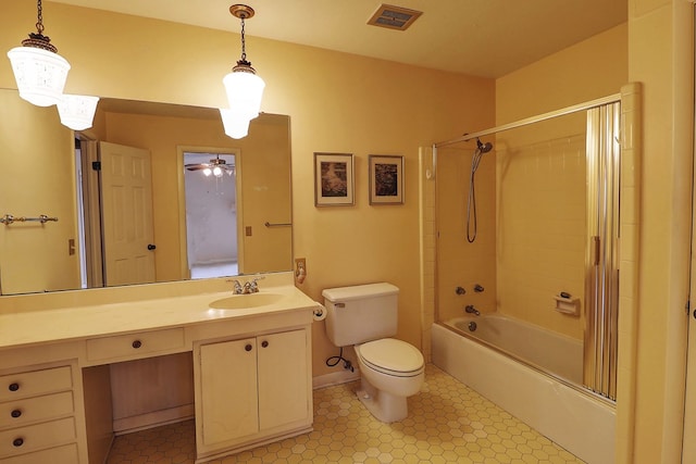 full bathroom featuring vanity, tiled shower / bath combo, and toilet