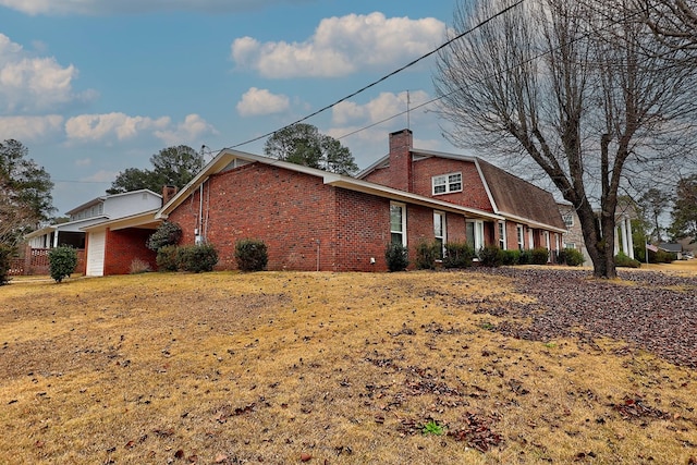 view of side of home with a lawn