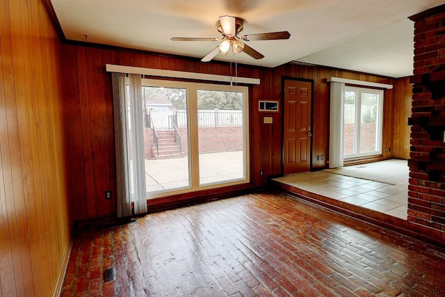 interior space with ceiling fan and wood walls