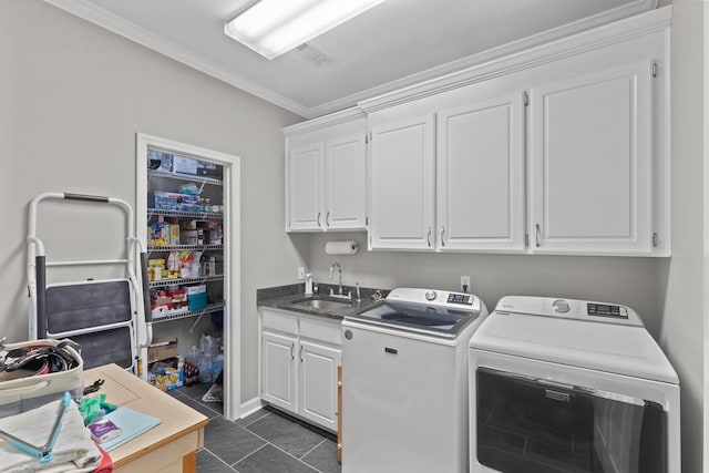 laundry area featuring cabinets, dark tile patterned flooring, sink, washer and dryer, and ornamental molding