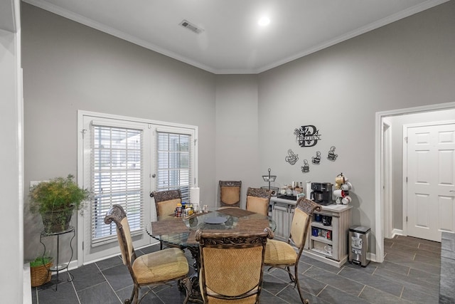 dining space with french doors and crown molding