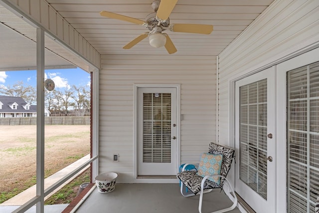 unfurnished sunroom featuring ceiling fan