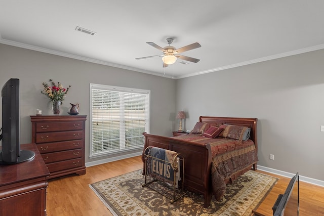 bedroom featuring ceiling fan, light wood-type flooring, and crown molding