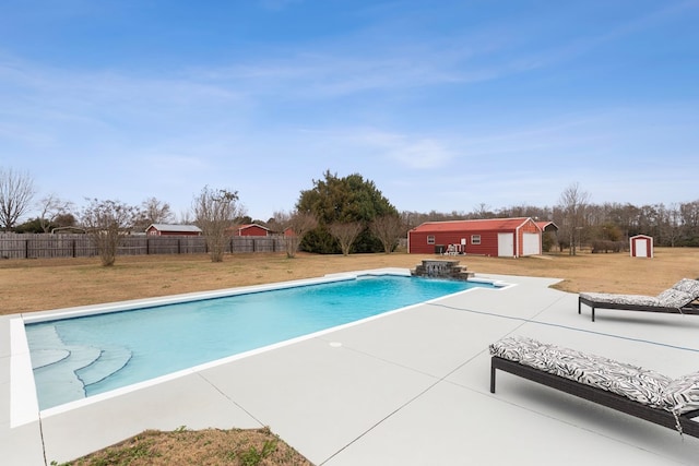 view of swimming pool featuring a yard, a patio, and an outdoor structure