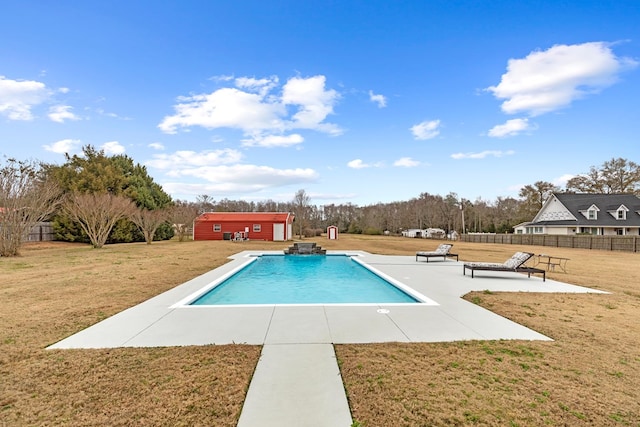 view of swimming pool with a lawn, an outbuilding, and a patio