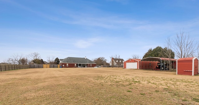 view of yard with a garage, an outdoor structure, and a carport